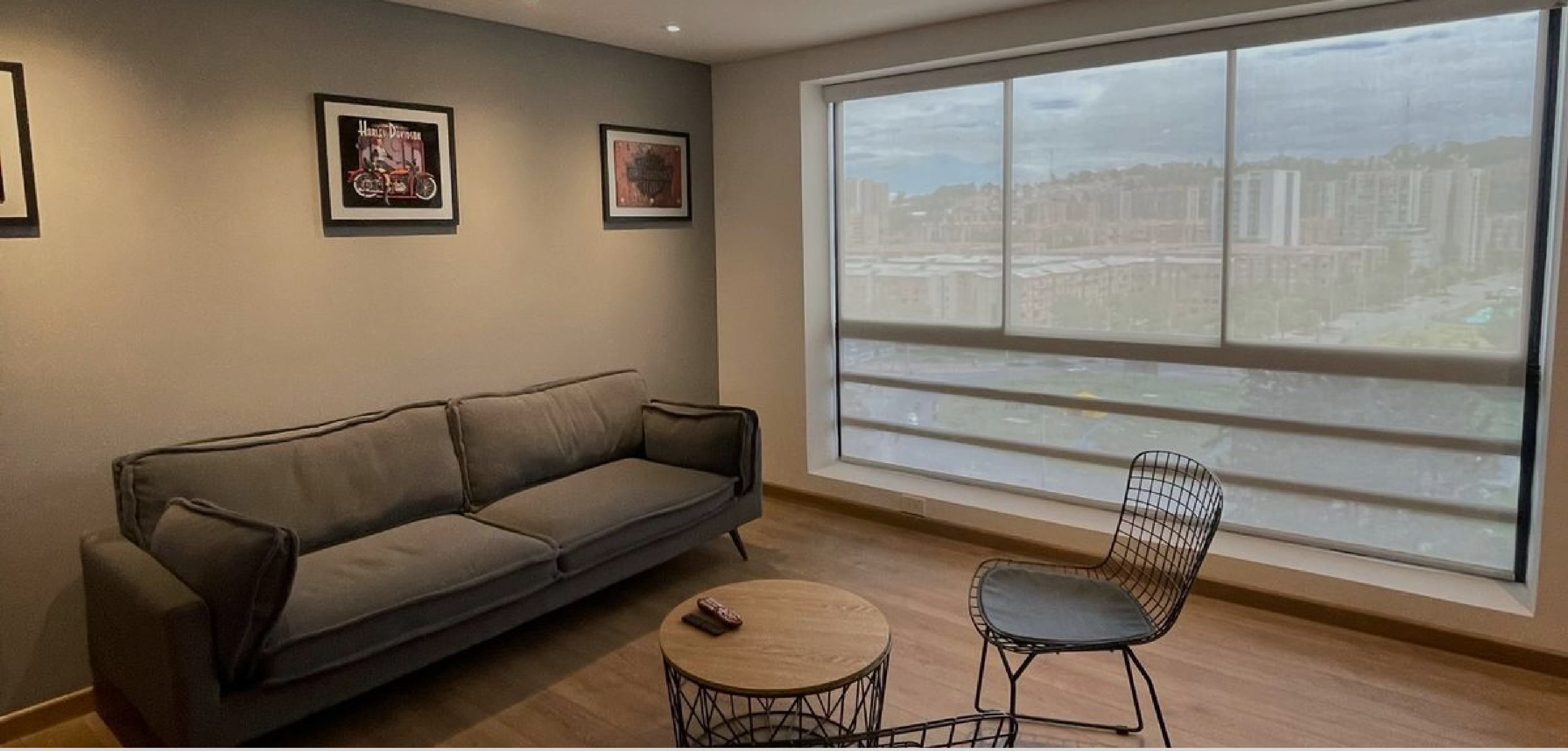 Sala moderna con cortinas enrollables motorizadas y grandes ventanales en Bogotá